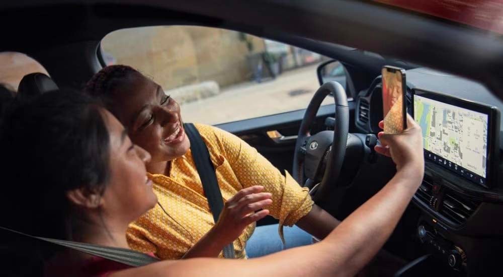 People are shown taking a selfie in a 2023 Ford Escape.