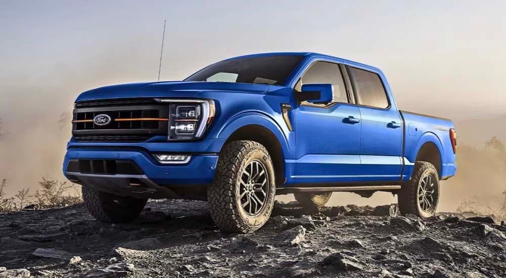 A blue 2023 Ford F-150 Tremor is shown parked off-road after visiting an Evansville truck dealer.