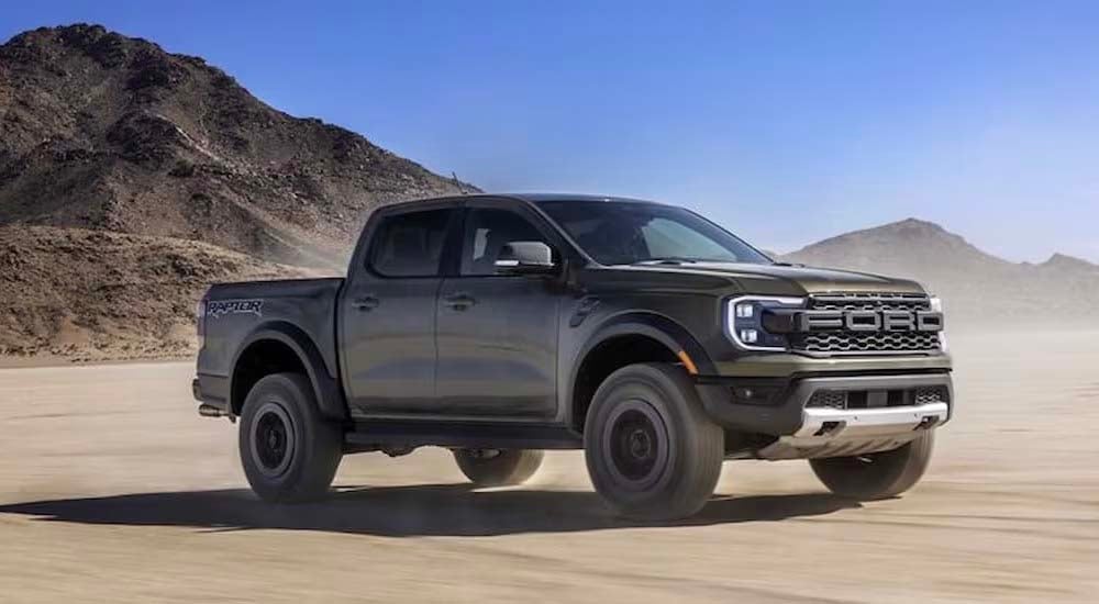 A green 2024 Ford Ranger Raptor is shown driving off-road.