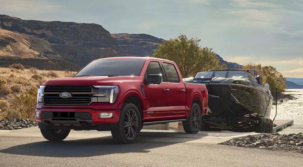 A red 2025 Ford F-150 Platinum towing a boat out of the water.