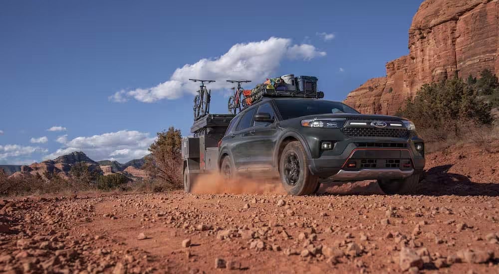 A green 2023 Ford Explorer Timberline is shown from the front at an angle while towing