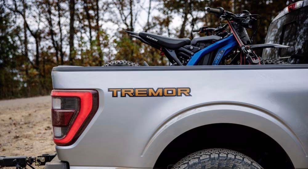 A silver 2021 Ford F-150 Tremor is shown from the side after leaving a Henderson Ford dealer.