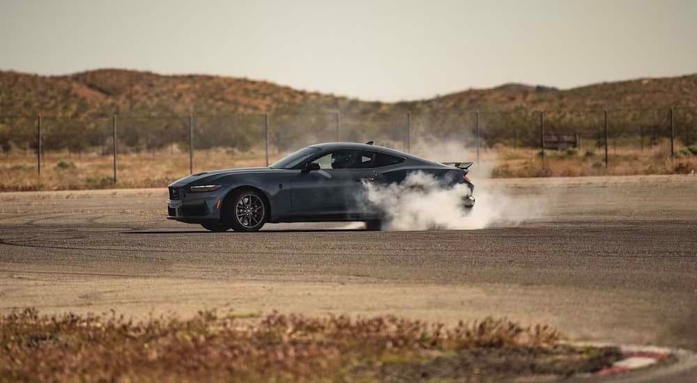 2024 Ford Mustang - Burnout.jpg A gray 2024 Ford Mustang is shown doing a burnout.