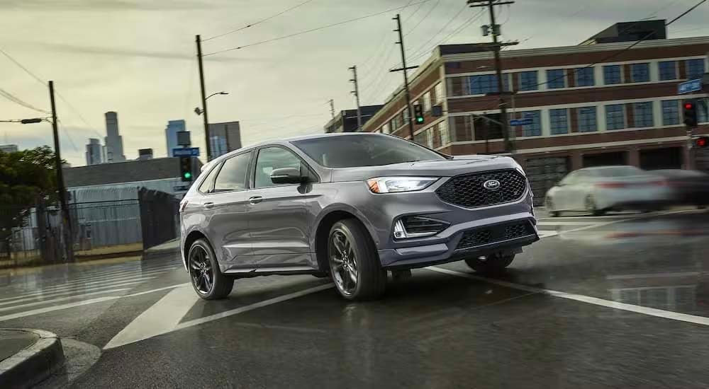 A silver 2022 Ford Edge ST is shown leaving a Melody Hill Ford dealer.