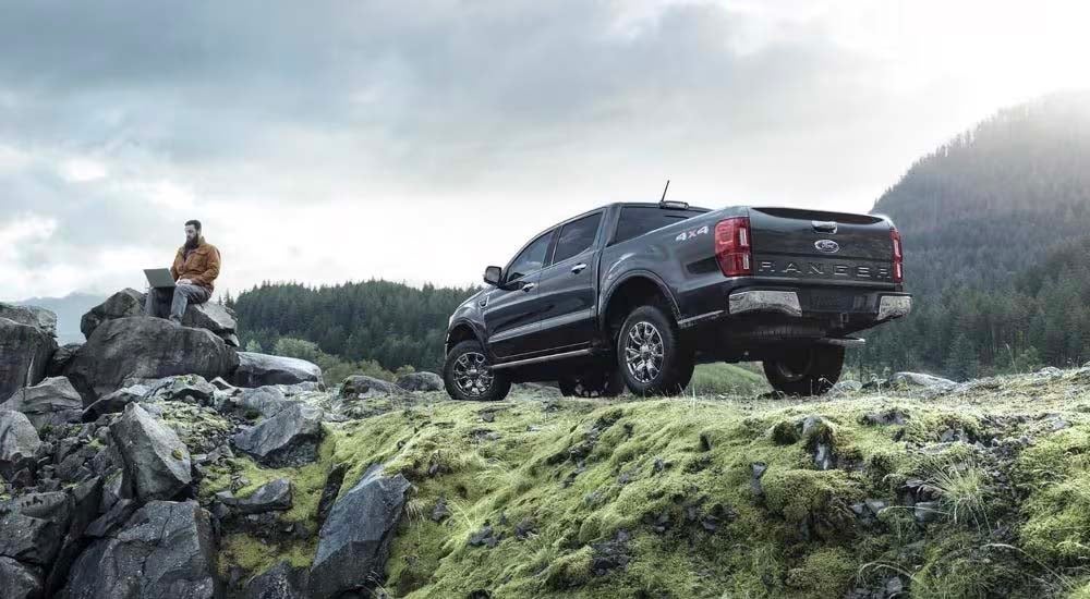 A dark grey 2023 Ford Ranger Lariat is shown from the rear on a trail after leaving a Ford Ranger