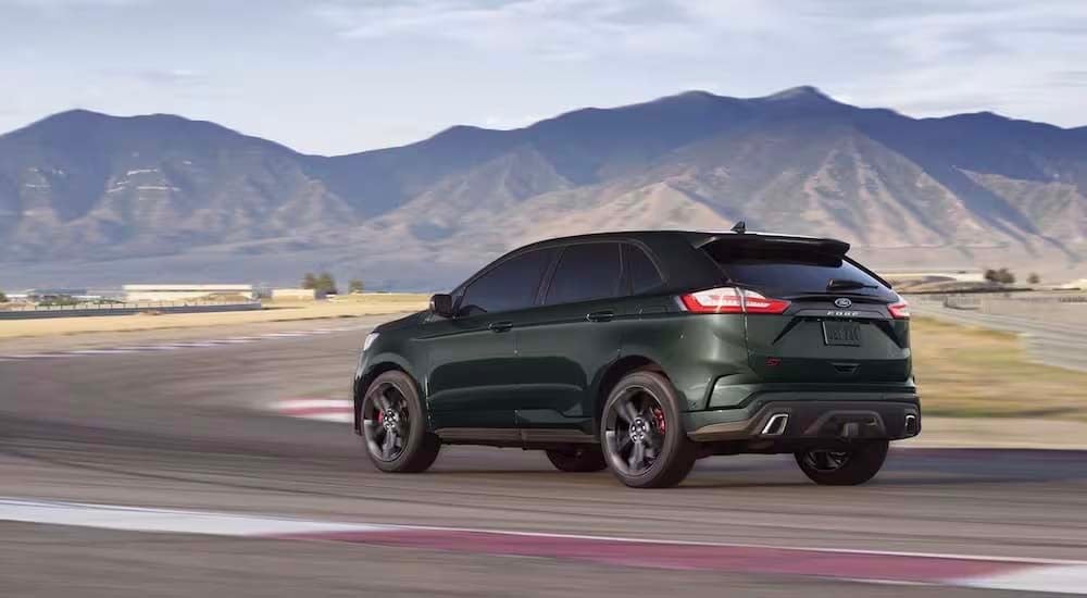 A green 2022 Ford Edge ST is shown from the rear driving on a race track.