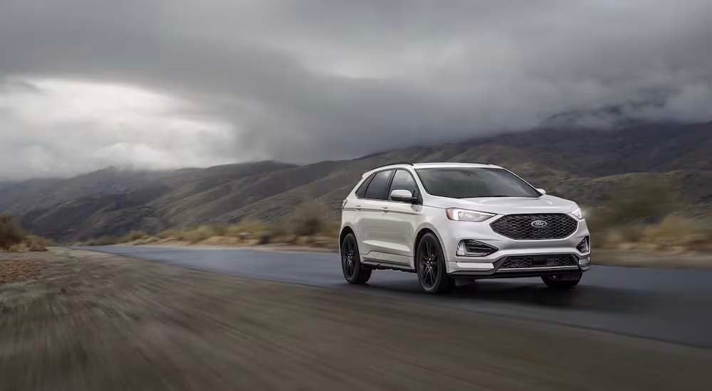A white 2022 Ford Edge is shown leaving a Mt. Vernon Ford dealer.