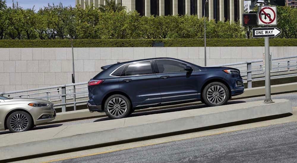 A blue 2022 Ford Edge Titanium Elite is shown from the side on a city street.
