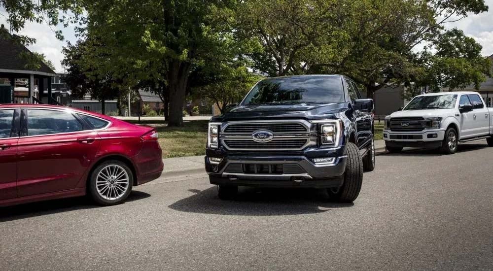 A black 2023 Ford F-150 is shown parallel parking after visiting a Ford F-150 dealer near Newburgh