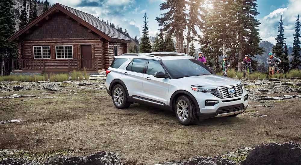 A white 2022 Ford Explorer is shown parked outside of a cabin after leaving a Ford Explorer dealer.