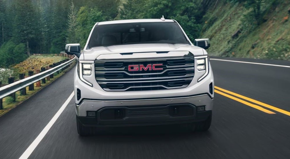A white 2025 GMC Sierra 1500 driving to a GMC dealer near Owatonna.