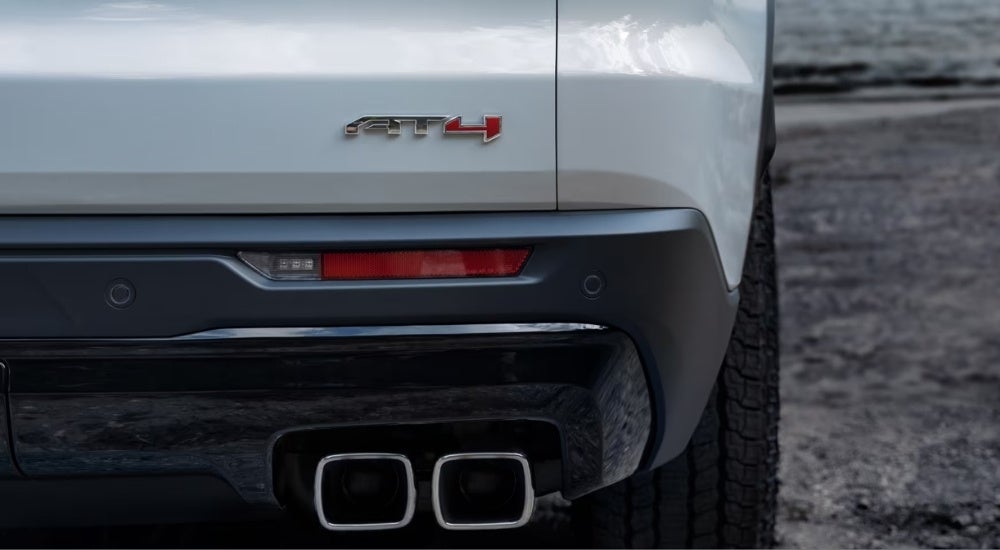 A close up shows the rear AT4 badge on a white 2024 GMC Acadia AT4.