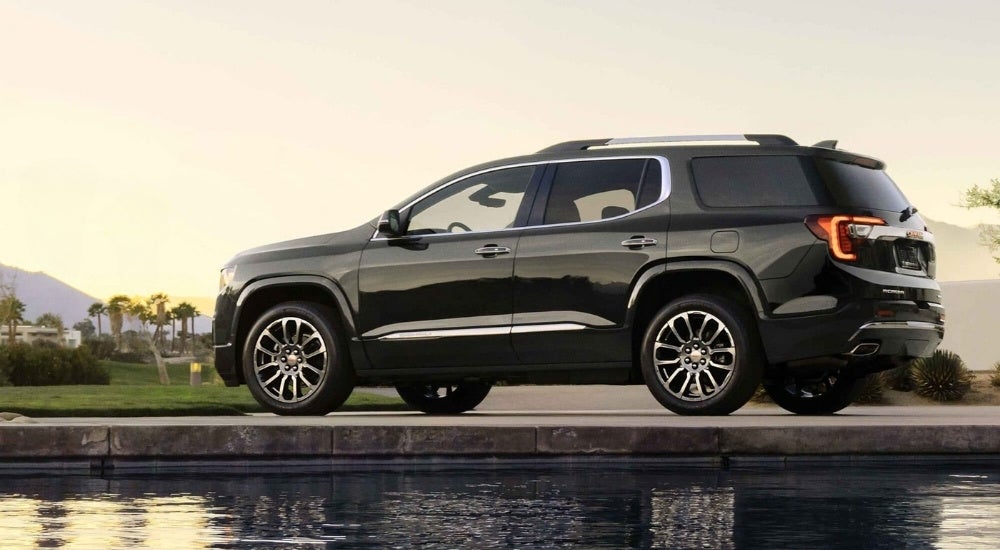 A black 2023 GMC Acadia Denali is shown from the side.