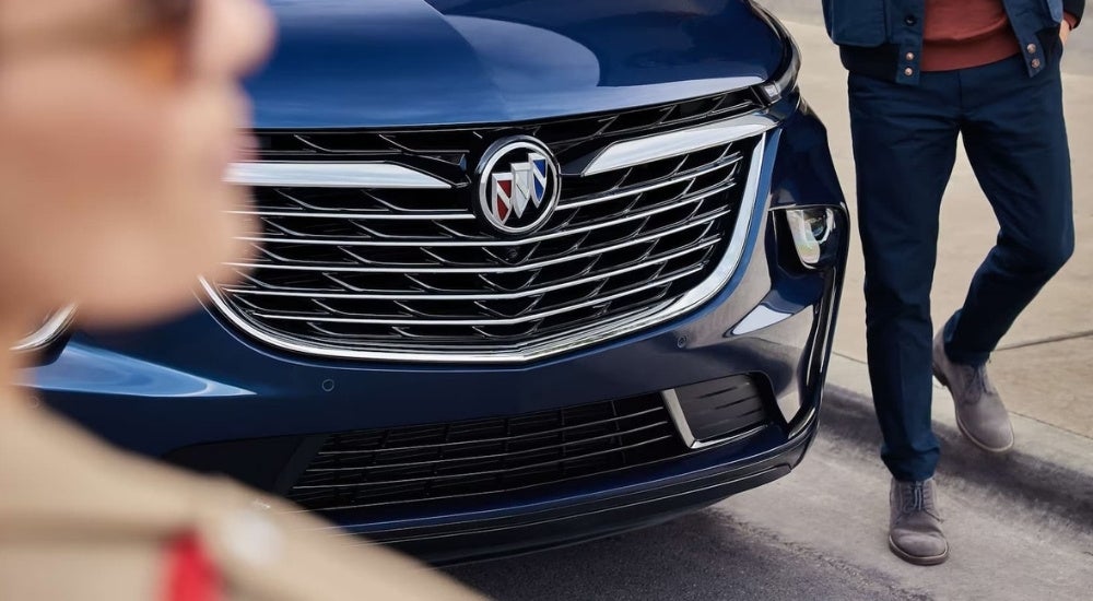A close-up shows the grille on a blue 2024 Buick Enclave.