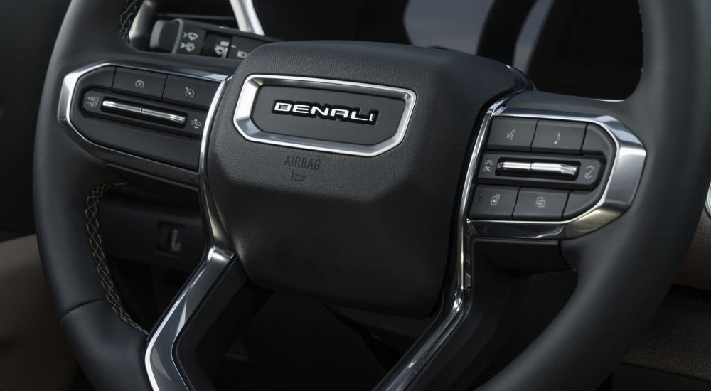 A close-up shows the steering wheel controls in a 2023 GMC Canyon Denali.