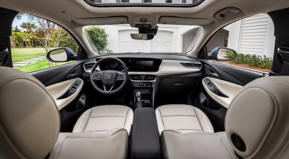 A close-up shows the front seats in a blue 2024 Buick Encore GX Avenir.