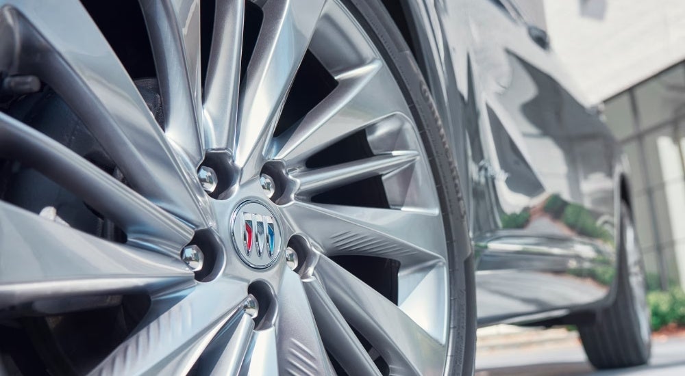 A close-up shows a silver wheel on a 2024 Buick Envision Avenir.