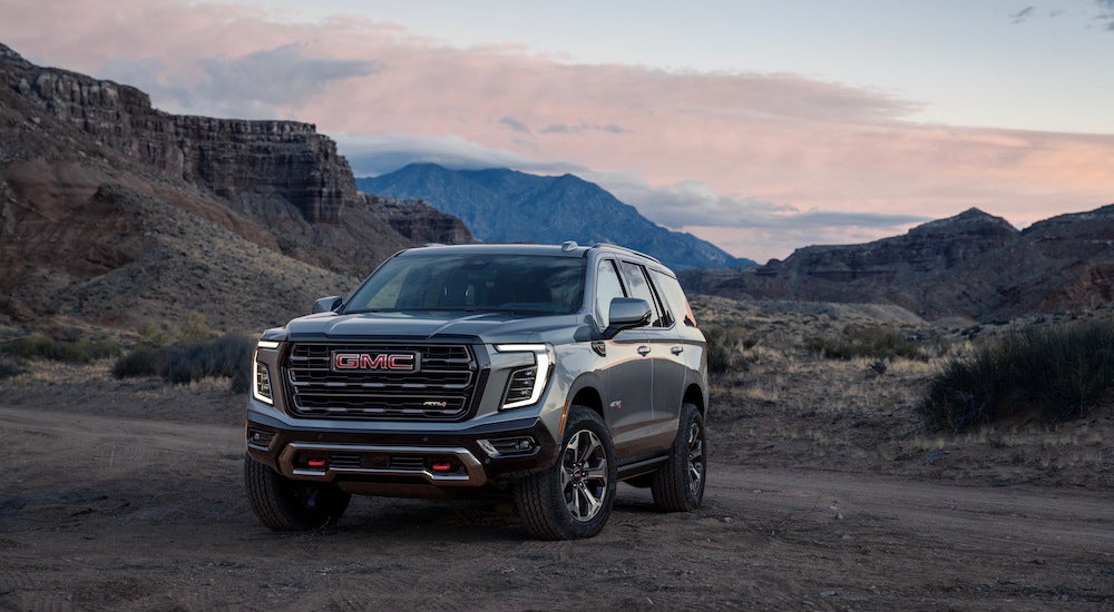 A grey 2025 GMC Yukon AT4 Ultimate is shown from the front at an angle after leaving a GMC dealer near Le Sueur.
