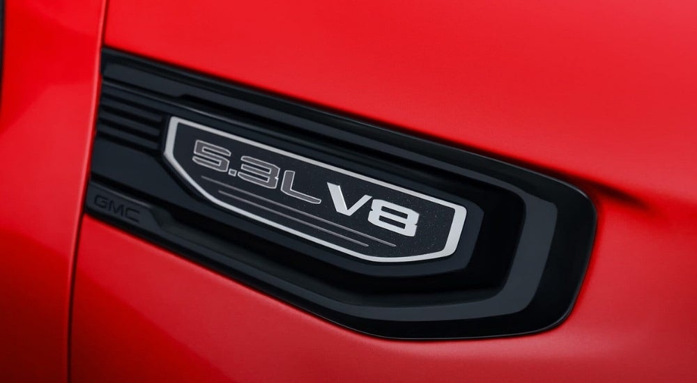 A close up shows badging on a red 2024 GMC Sierra 1500.