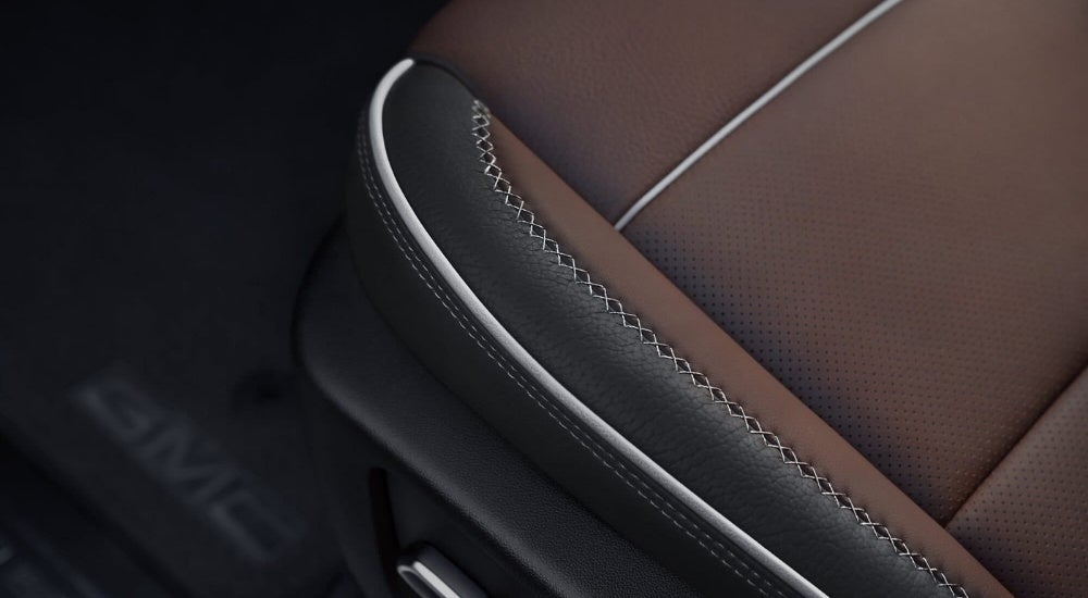 A close up shows black and brown leather details on a 2023 GMC Sierra 1500 Denali.