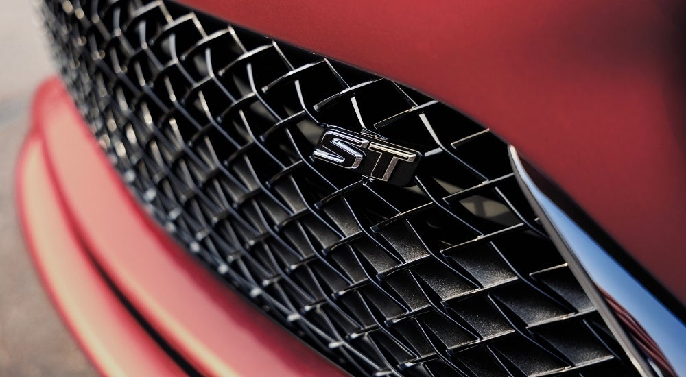 A close-up shows the ST badge on a red 2024 Buick Envista ST.
