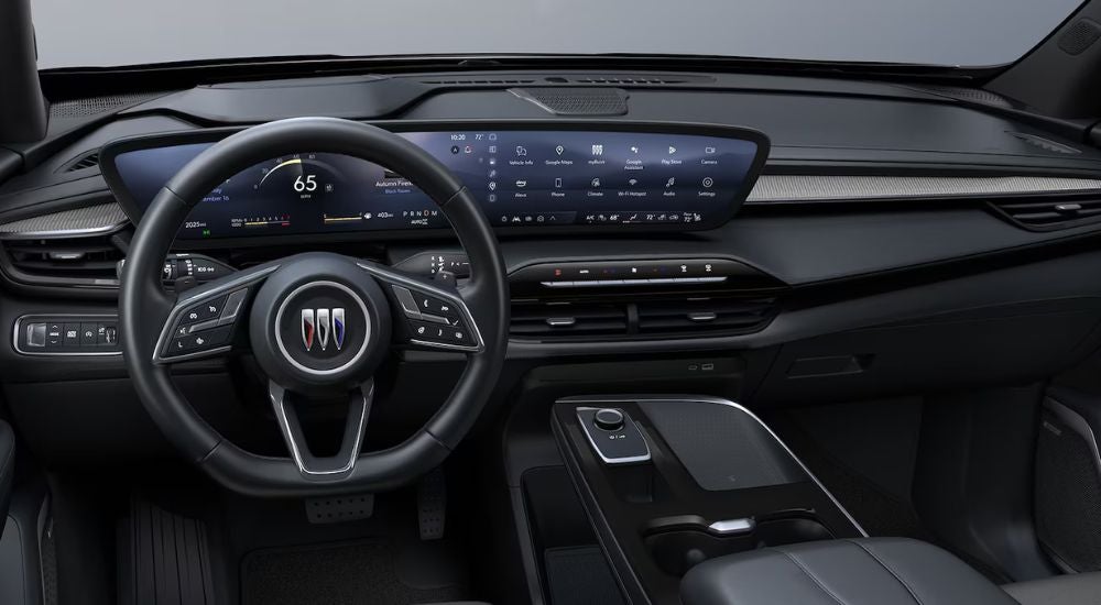 The steering wheel and infotainment screens in a 2025 Buick Enclave Sport Touring.