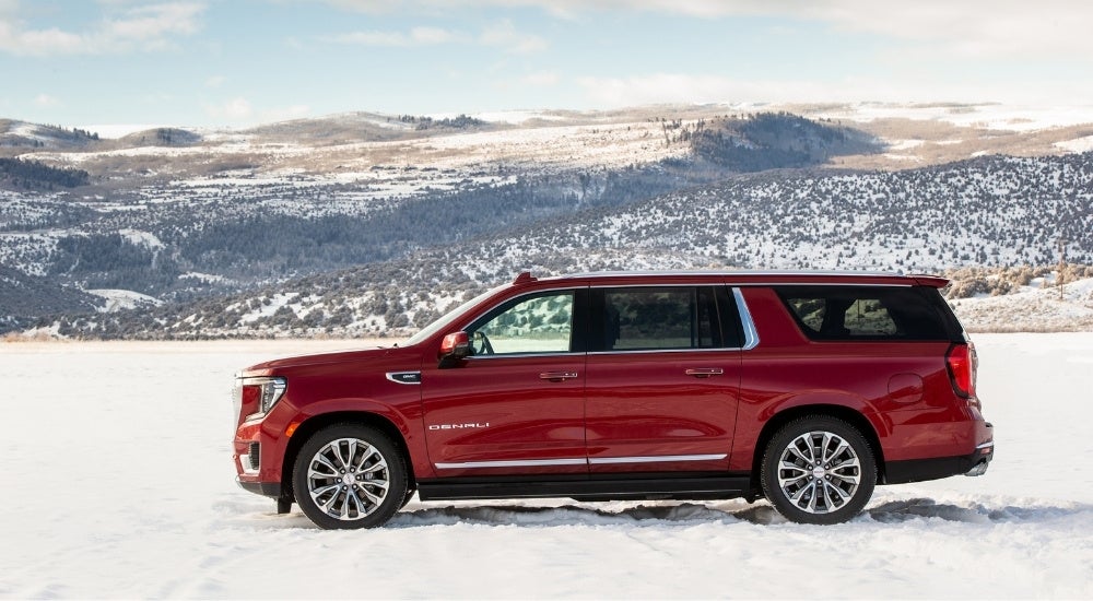 A red 2021 GMC Yukon XL Denali is shown from the side.