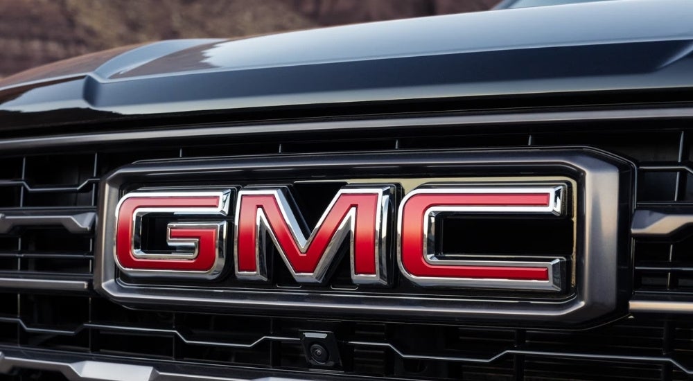 A close up shows the GMC badge on a black 2025 GMC Yukon XL.