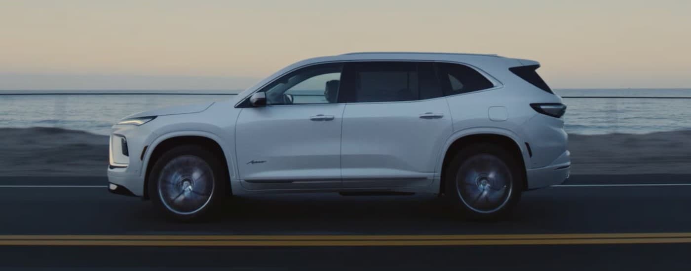A white 2026 Buick Enclave driving on a highway.