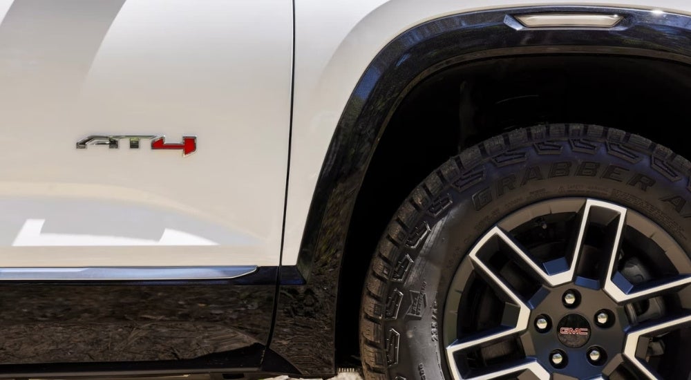 A close-up shows the AT4 badge on a white 2025 GMC Terrain AT4.