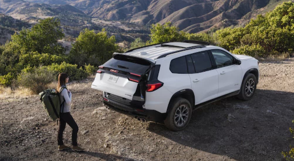 A white 2025 GMC Acadia AT4 parked with its tailgate open.