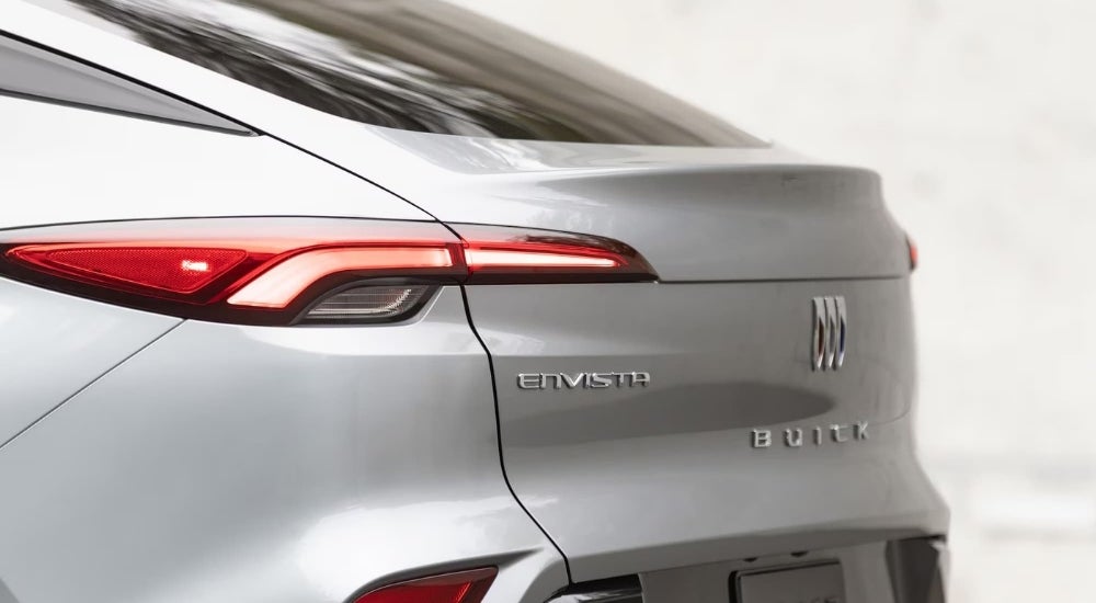 A close-up shows the drive side taillight on a silver 2024 Buick Envista.