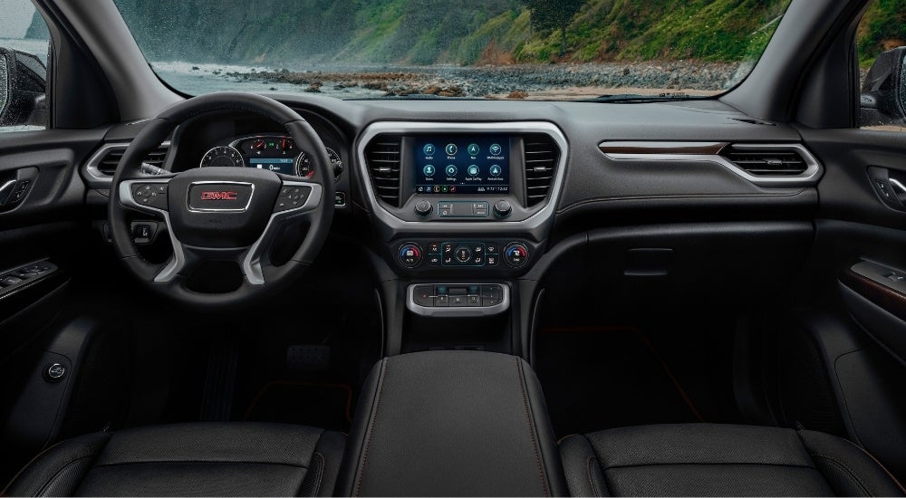 The black dash and interior are shown in a 2023 GMC Acadia AT4.