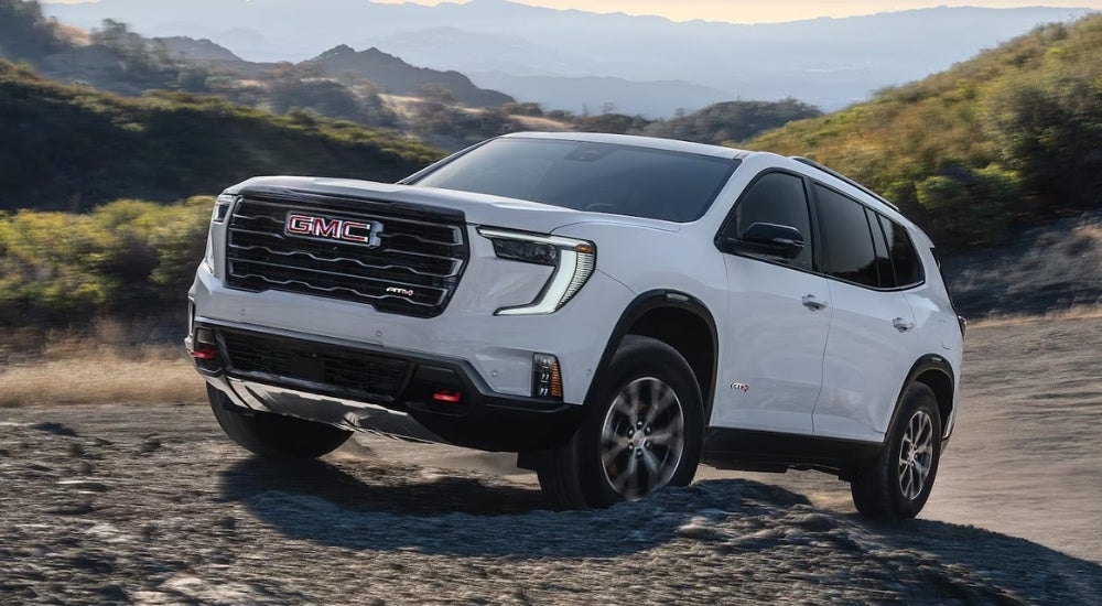A white 2026 GMC Acadia AT4 off-roading
