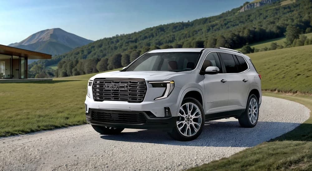 A white 2026 GMC Acadia AT4 parked on a driveway.