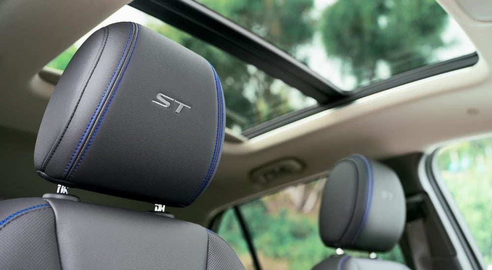 A close-up shows black leather headrests in a 2025 Buick Encore GX ST.