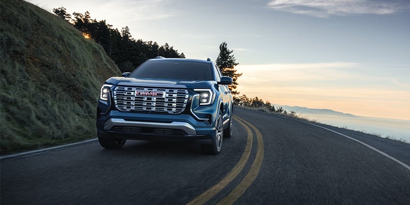 2026 GMC Terrain driving on winding mountain road, front view
