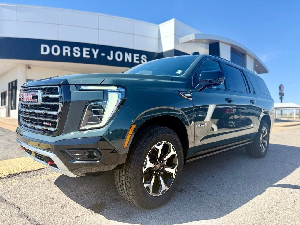 A green GMC SUV parked in front of a dealership with the 'Dorsey-Jones' sign in the background