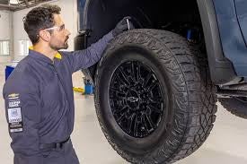 Checking tire pressure and tread before summer road trips in Alabama
