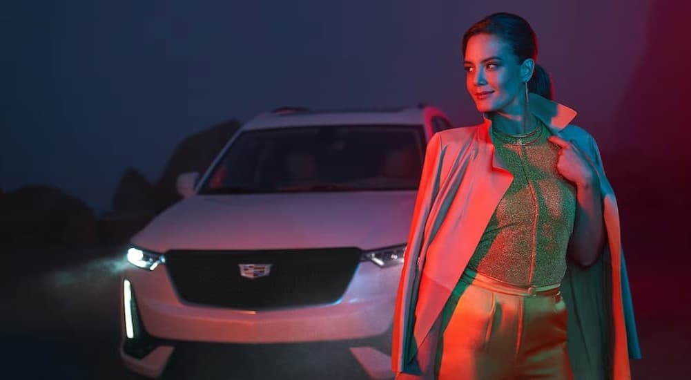 A person near a white 2024 Cadillac XT6.