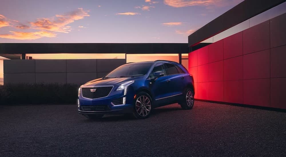 A blue 2024 Cadillac XT5 parked on a driveway.
