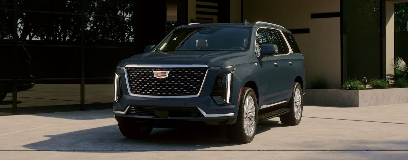 A blue 2027 Cadillac Escalade parked on a driveway.