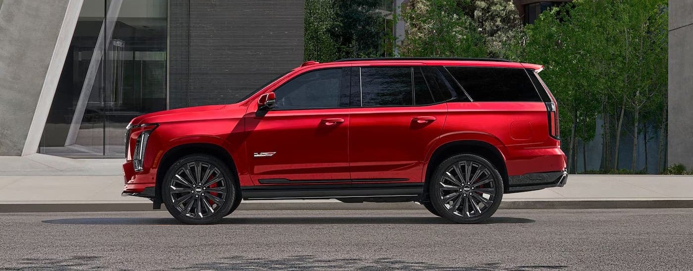 A red 2027 Cadillac Escalade parked in a city.