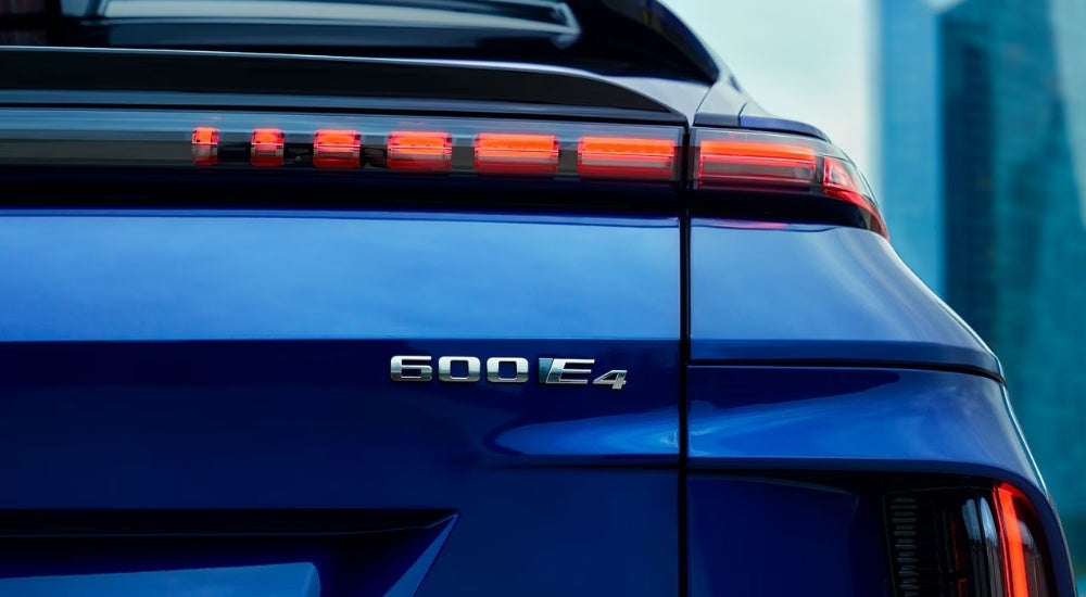 A close-up shows the read badging on a blue 2024 Cadillac LYRIQ.
