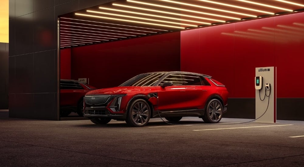 A red 2024 Cadillac LYRIQ for sale parked at a charging station.