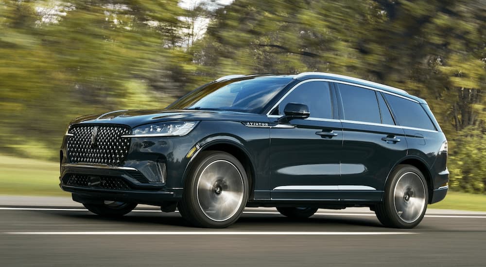 Green 2025 Lincoln Aviator driving on an open road