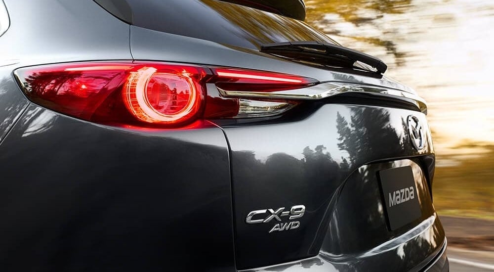 A close-up shows the drive side taillight on a grey 2022 Mazda CX-9.