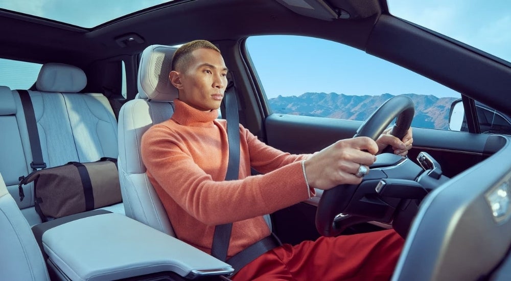 A person is shown driving a 2024 Cadillac LYRIQ.