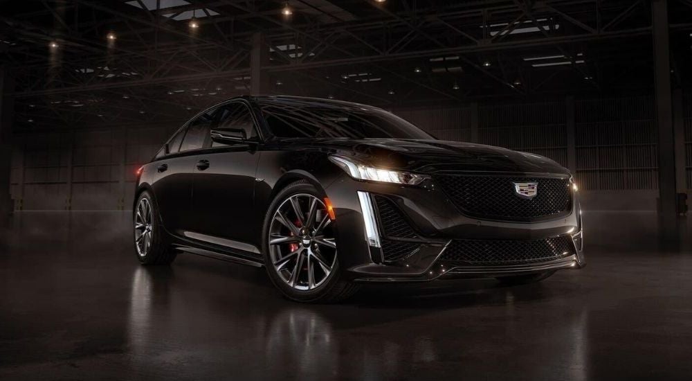 A black 2024 Cadillac CT5-V is shown parked in a warehouse after visiting a Cadillac dealer near Janesville.
