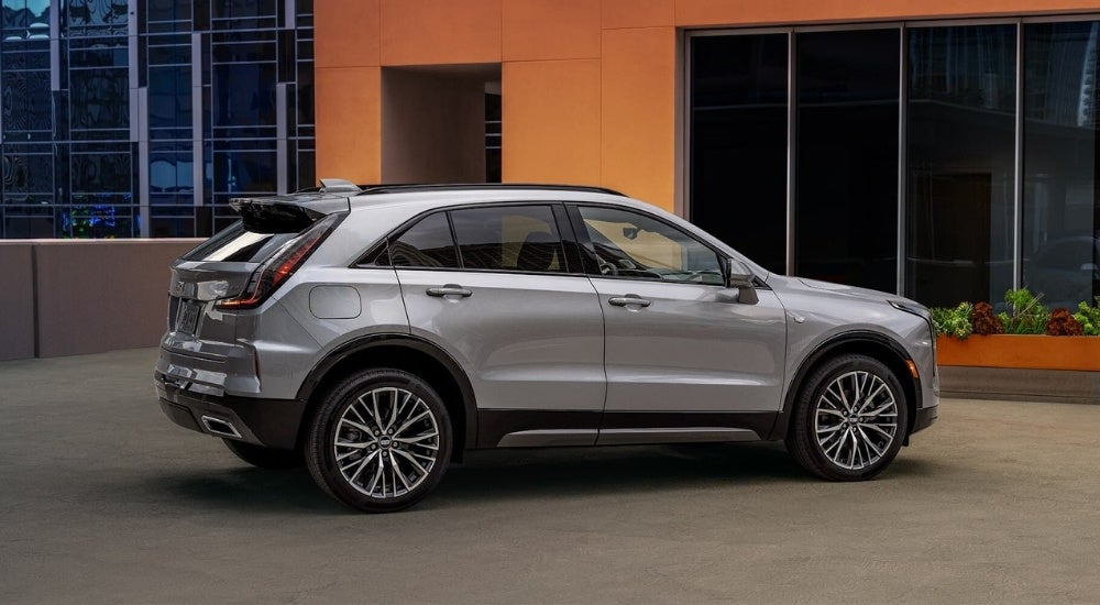 A grey 2024 Cadillac XT4 is shown parked in front of a building.